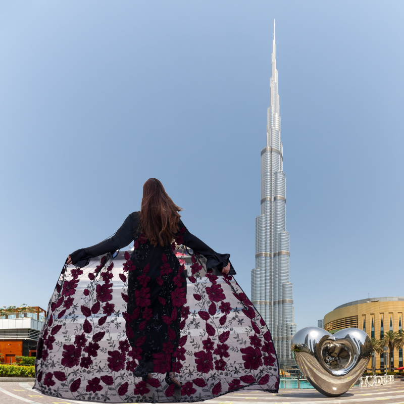 Luxurious silk maxi paired with feather-pattern cape