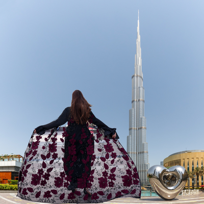 Luxurious silk maxi paired with feather-pattern cape